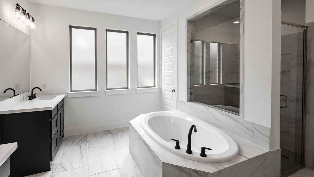 Full bathroom with marble finish floor, vanity, a shower stall, baseboards, and a bath