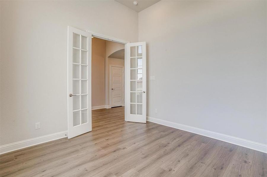 Unfurnished room featuring light hardwood / wood-style flooring and french doors