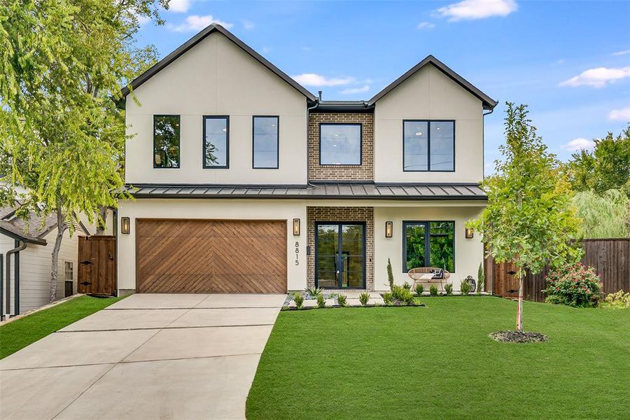 Contemporary house featuring stucco siding, concrete driveway, a standing seam roof, and a garage Contemporary house featuring stucco siding, concrete driveway, a standing seam roof, and a garage