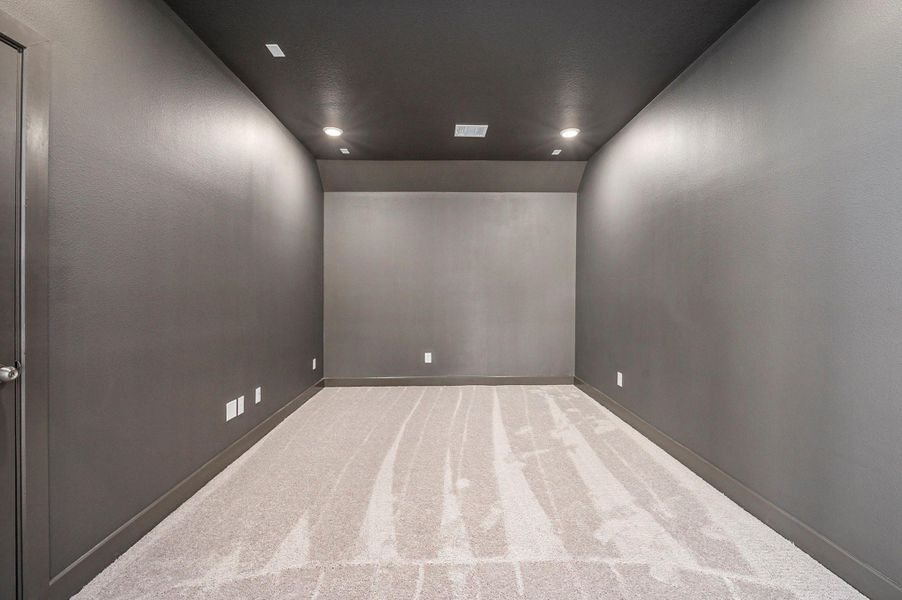 The spacious media room provides the perfect setting for movie nights and entertainment. Designed for comfort and style, this inviting space offers ample room for seating, optimal acoustics, and a cozy atmosphere—ideal for enjoying your favorite films or hosting family gatherings in luxury.