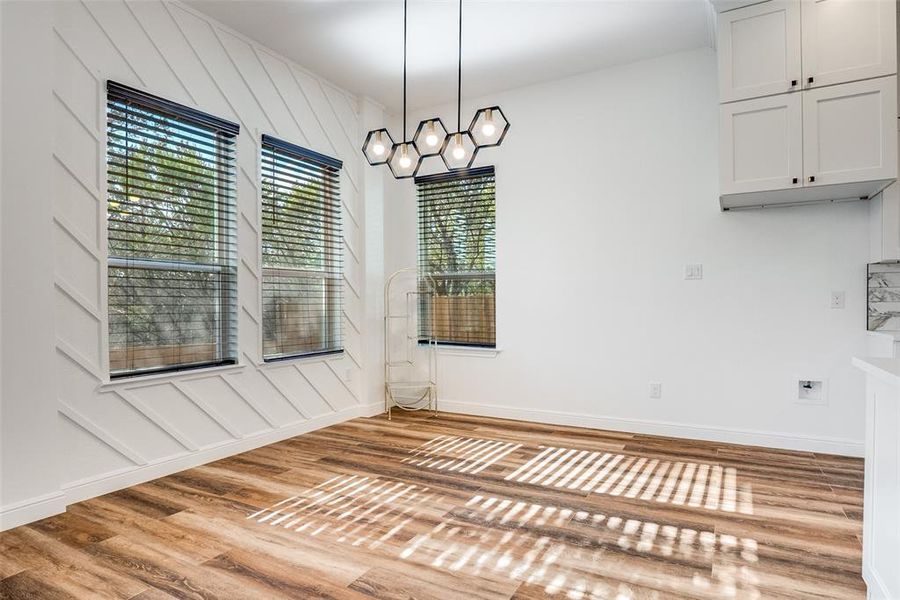 Unfurnished dining area with light wood finished floors and baseboards