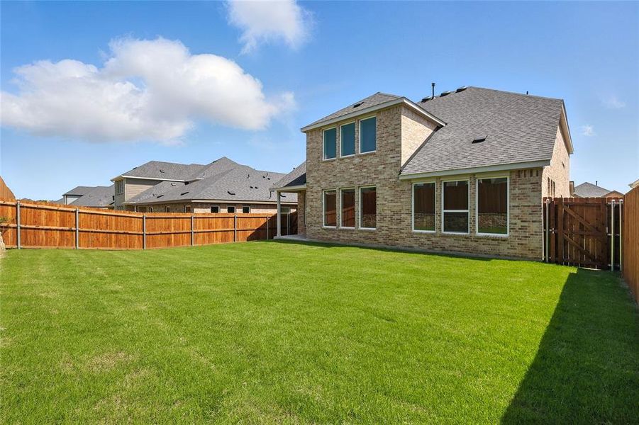Back of house with brick siding, a fenced backyard, and roof with shingles Back of house with brick siding, a fenced backyard, and roof with shingles