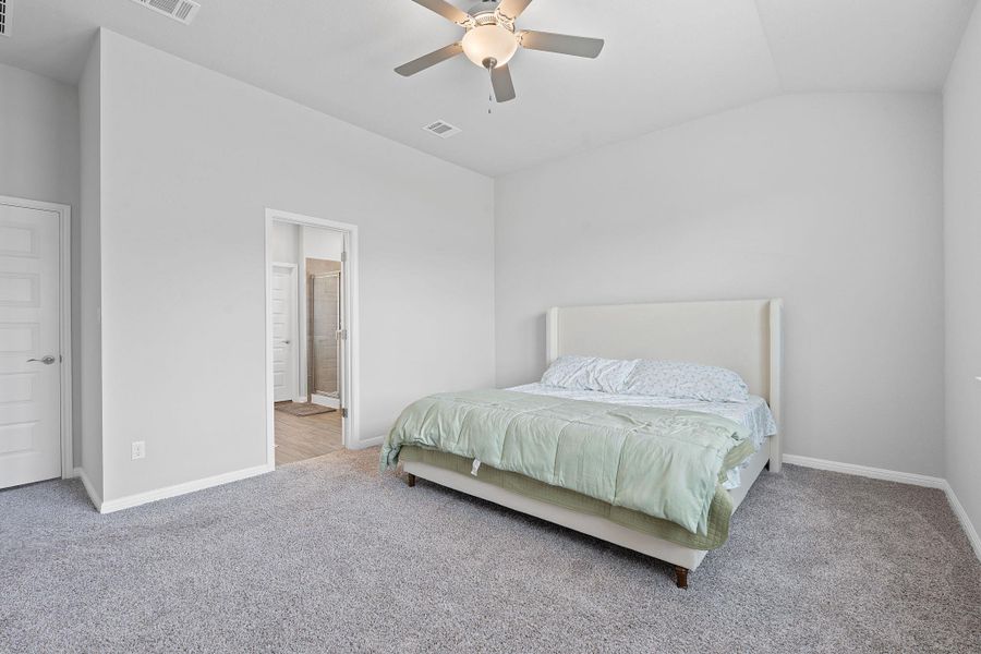 Carpeted bedroom with vaulted ceiling, visible vents, baseboards, and ceiling fan Carpeted bedroom with vaulted ceiling, visible vents, baseboards, and ceiling fan