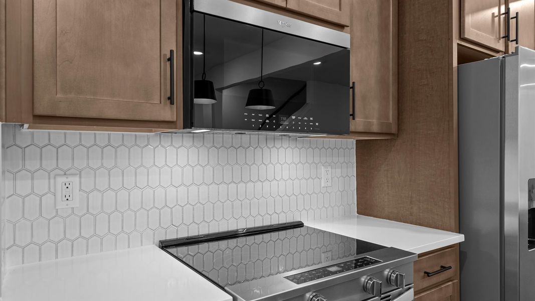 Superior kitchen with quartz countertops, pendant lighting, and a generously sized island Superior kitchen with quartz countertops, pendant lighting, and a generously sized island