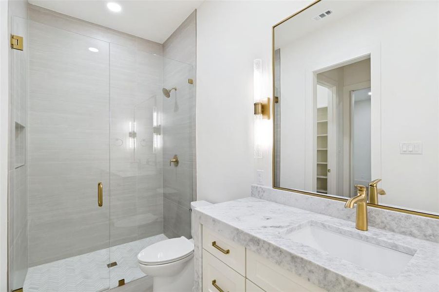 Bathroom featuring a glass-enclosed shower with light-toned wall tiling and hexagonal floor tiles Bathroom featuring a glass-enclosed shower with light-toned wall tiling and hexagonal floor tiles