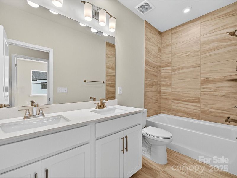 Secondary Bathroom with Upgraded Shower and Dual Vanity.