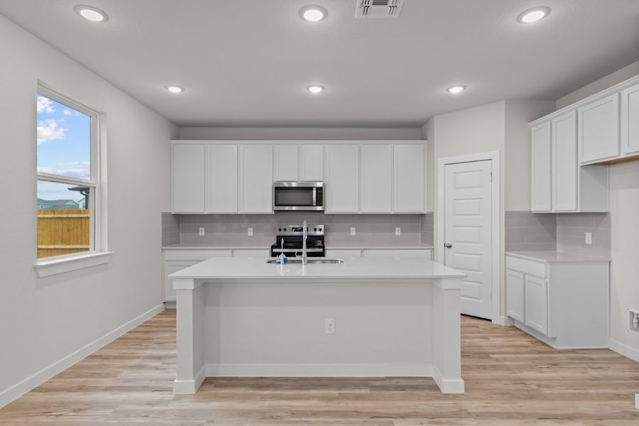 A kitchen with white cabinets.