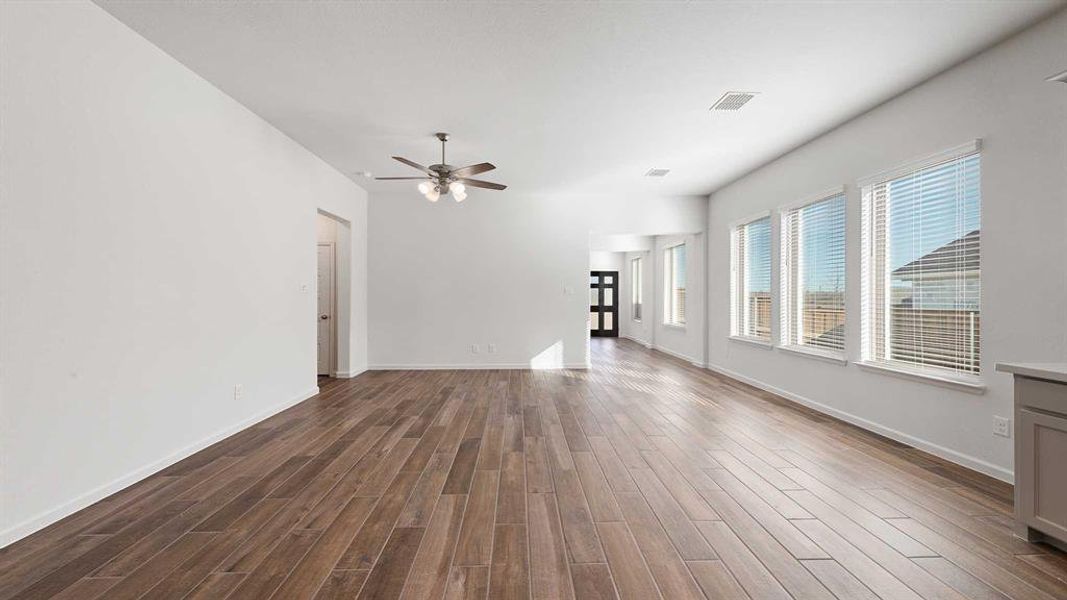 Unfurnished living room with ceiling fan and dark hardwood / wood-style flooring