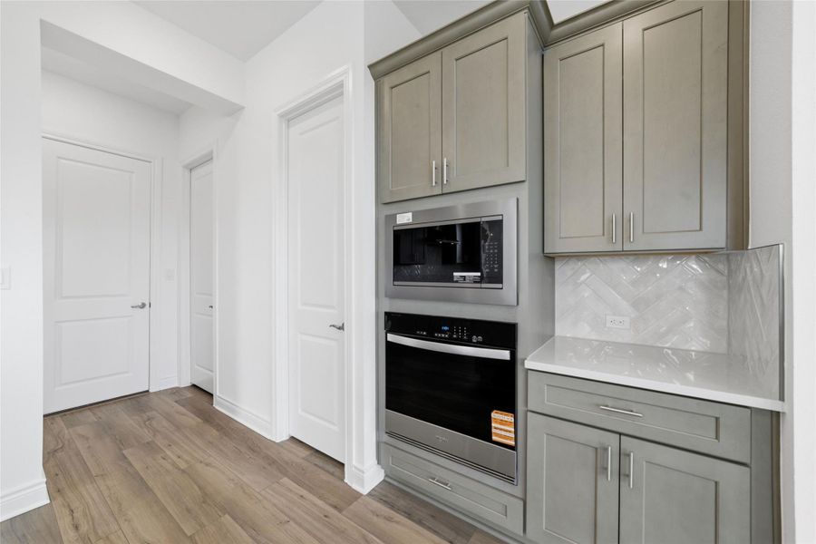 Modern, abundant cabinetry paired with elegant quartz countertops adds a luxurious and sophisticated touch to the home.
