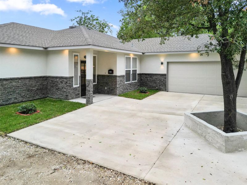 View of front facade featuring stone siding, stucco siding, concrete driveway, a garage, and a shingled roof View of front facade featuring stone siding, stucco siding, concrete driveway, a garage, and a shingled roof
