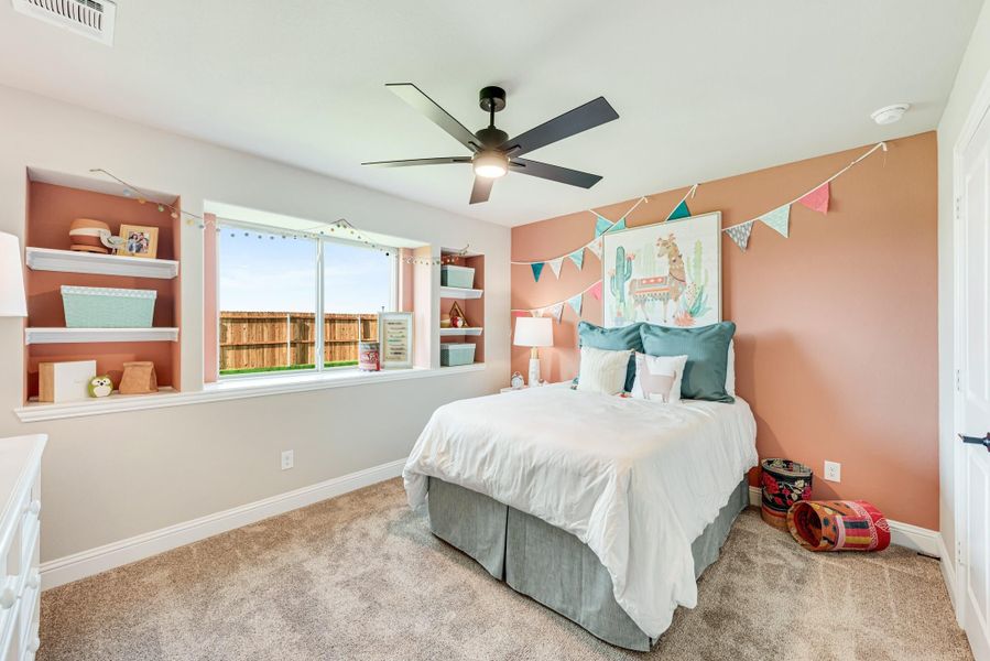 Child's bedroom with pink accent wall, built-in shelves, ceiling fan, and large window