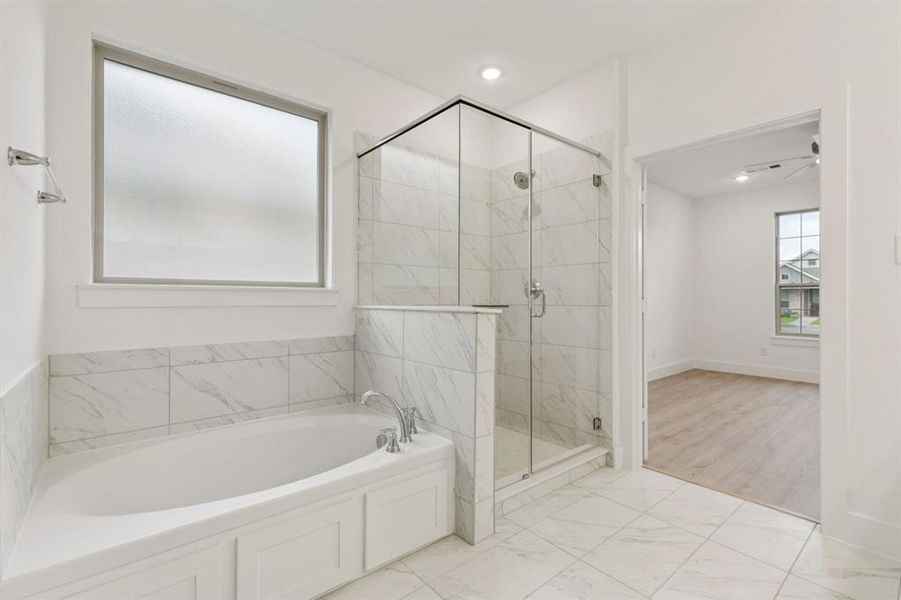 Bathroom with a bath, a stall shower, and marble look tile flooring Bathroom with a bath, a stall shower, and marble look tile flooring