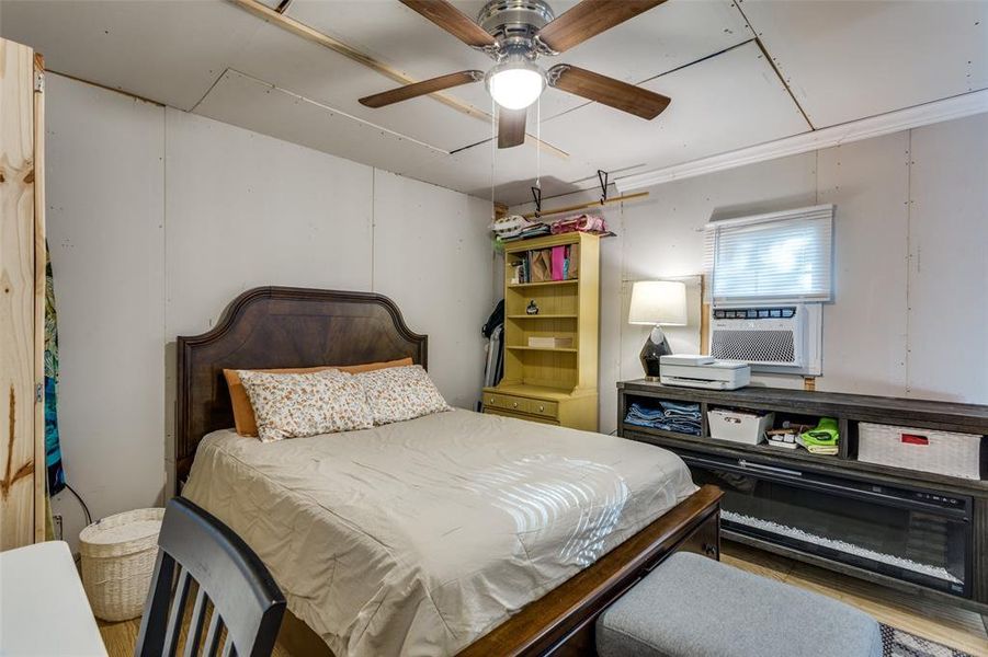 Bedroom with cooling unit, ornamental molding, and ceiling fan