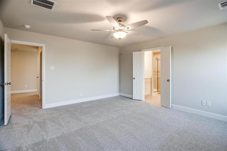 Unfurnished bedroom featuring light carpet, ceiling fan, and ensuite bathroom Unfurnished bedroom featuring light carpet, ceiling fan, and ensuite bathroom