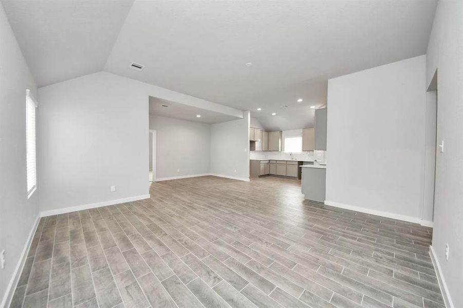 Family room flooded with natural light through the expansive windows.  The premium tile flooring adds a touch of luxury to the space, creating the perfect setting for relaxing moments and cherished gatherings with loved ones.