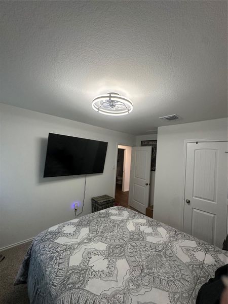 Bedroom featuring a textured ceiling, a closet, and carpet floors