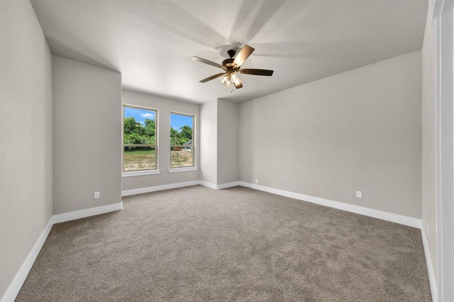 Carpeted spare room with ceiling fan