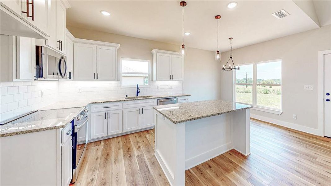 Kitchen featuring stainless steel appliances, light wood-style flooring, plenty of natural light, and recessed lighting Kitchen featuring stainless steel appliances, light wood-style flooring, plenty of natural light, and recessed lighting