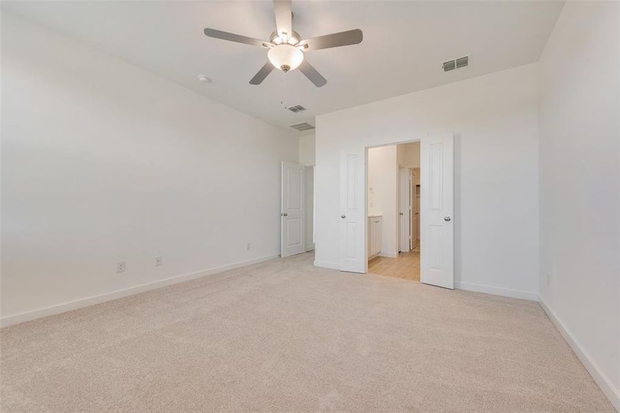 Unfurnished bedroom featuring ceiling fan and light colored carpet