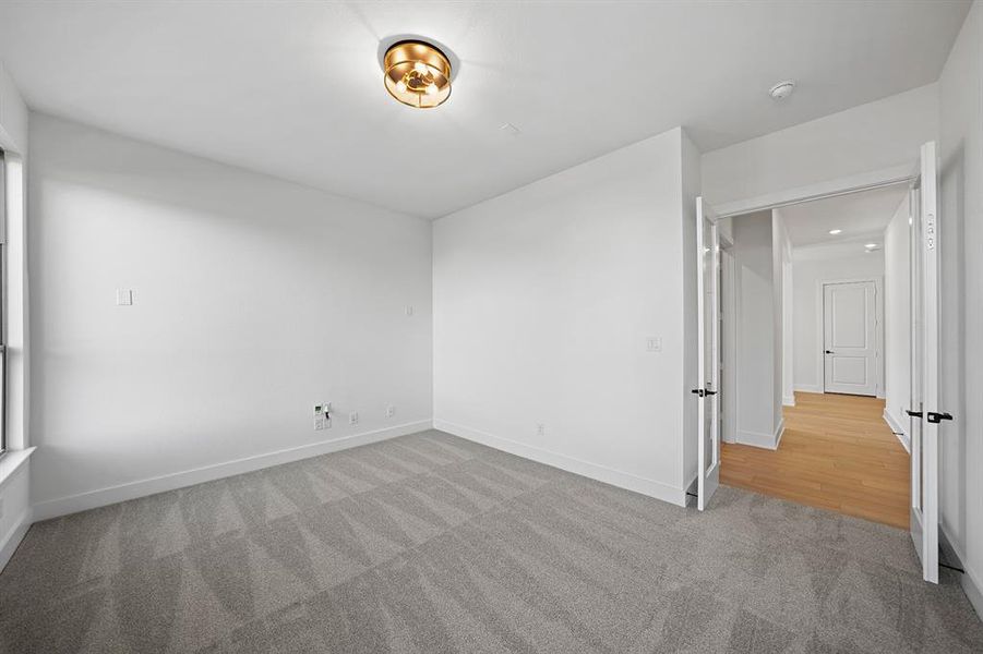 Unfurnished bedroom featuring light colored carpet and baseboards