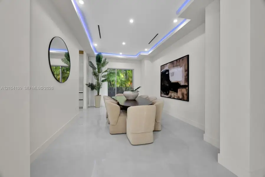 Tray ceiling featuring recessed accent lighting, large-format tile flooring, and sliding glass doors