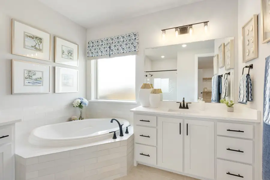 Master bathroom with soaking tub, white subway tile surround, and white vanity with large mirror Master bathroom with soaking tub, white subway tile surround, and white vanity with large mirror
