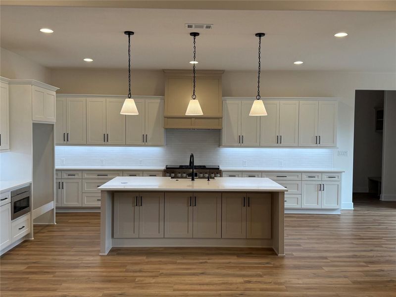 Custom made cabinets by Liberty Hill craftsman, and lots of them.  A white theme looks soft but not busy like a country kitchen should.