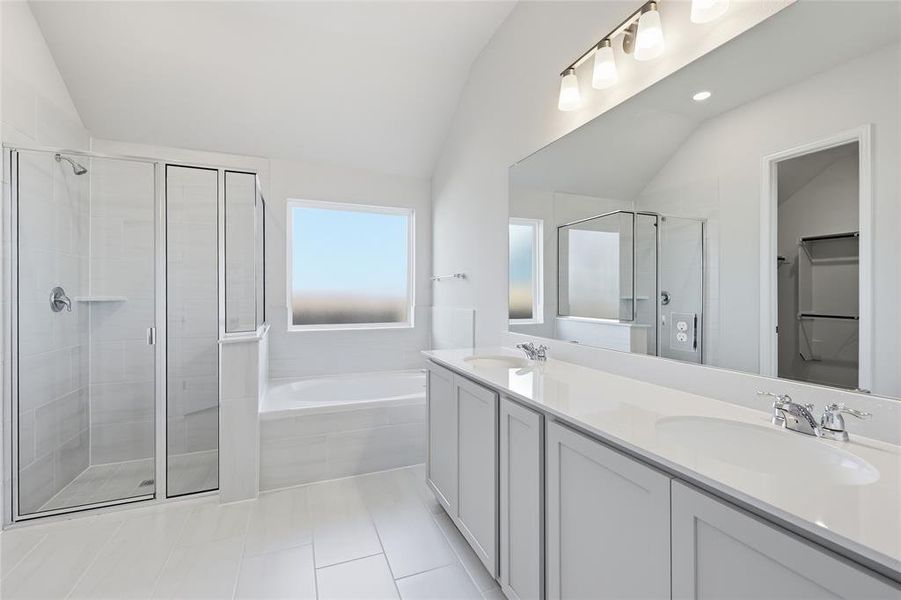 Bathroom with double vanity, lofted ceiling, a stall shower, a spacious closet, and a bath Bathroom with double vanity, lofted ceiling, a stall shower, a spacious closet, and a bath