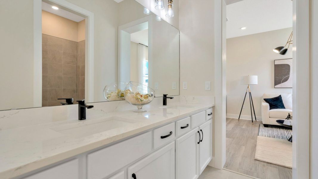 The Jack and Jill Bathroom of a DRB Homes Grand Eider model, which is a home plan offered at Serengeti in Spring Hill, FL.
