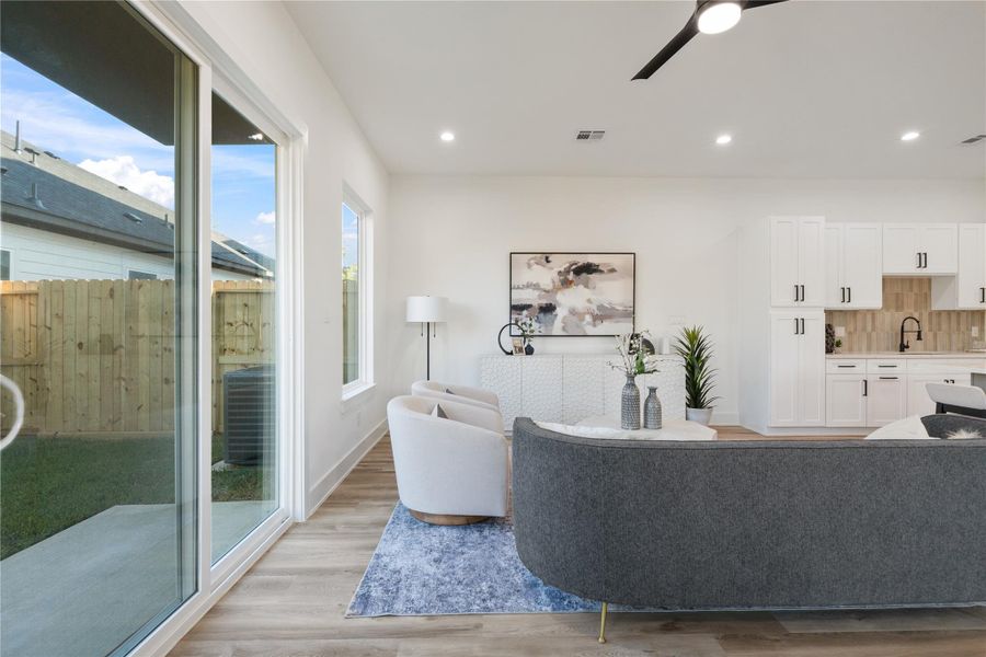 Eight-foot sliding doors seamlessly connect the living area to the oversized backyard, creating a perfect indoor-outdoor flow. They fill the space with natural light while providing easy access for entertaining or relaxing outside. This design enhances both functionality and the home’s airy, open feel.