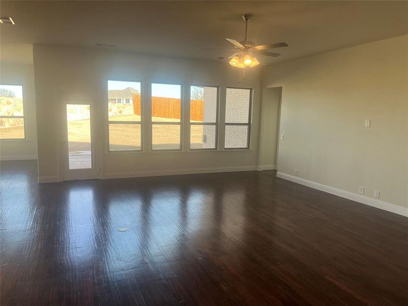 Unfurnished room with ceiling fan and dark wood-type flooring