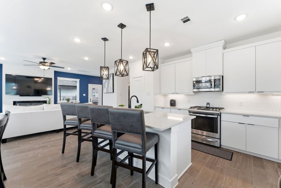 Large quartz island with bar seating provides the perfect hub for casual dining, entertaining, or morning coffee.