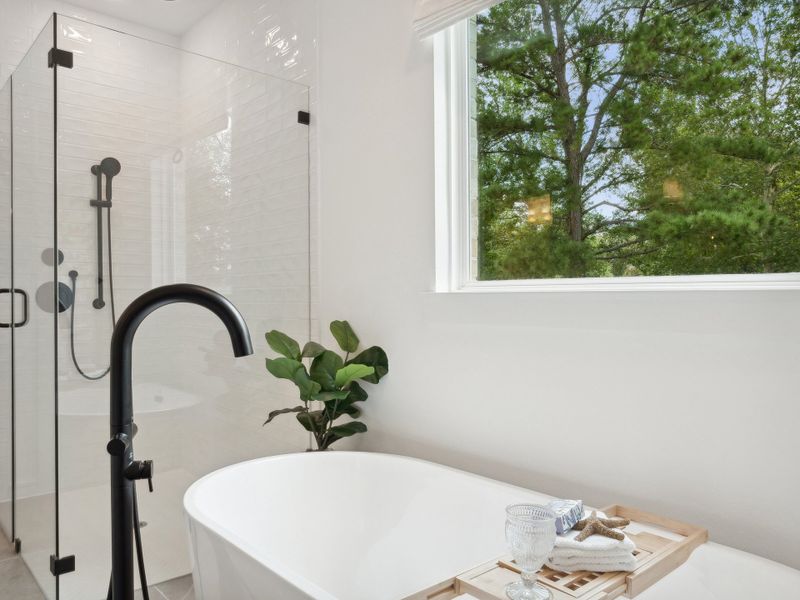 Primary bath with freestanding soaking tub & glass shower enclosure