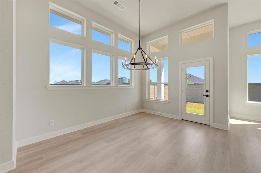 High ceilings featuring a multi-paned window array and a modern chandelier