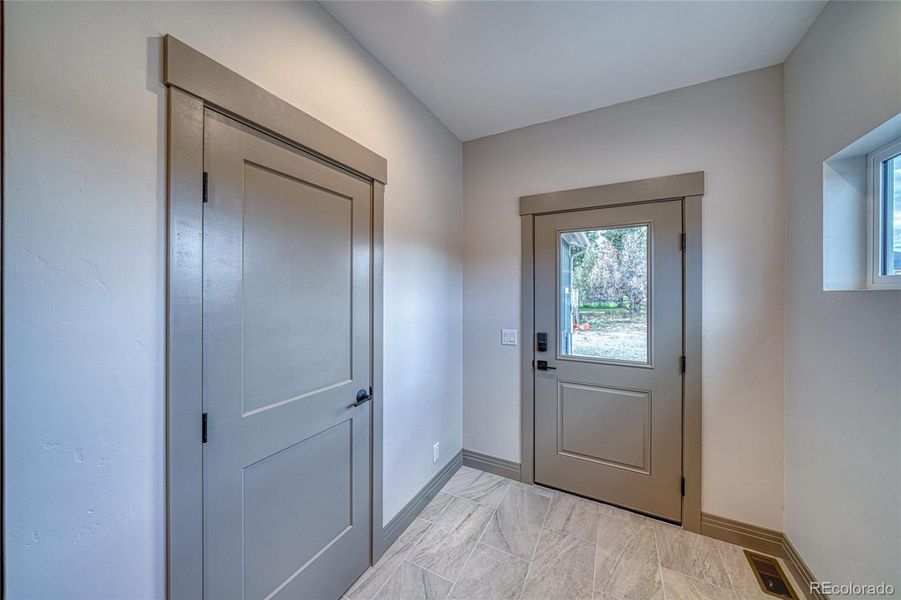 Coat closet and exterior door to the back.