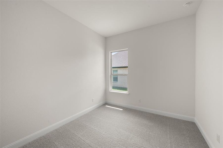 Unfurnished room with light carpet and a smoke detector