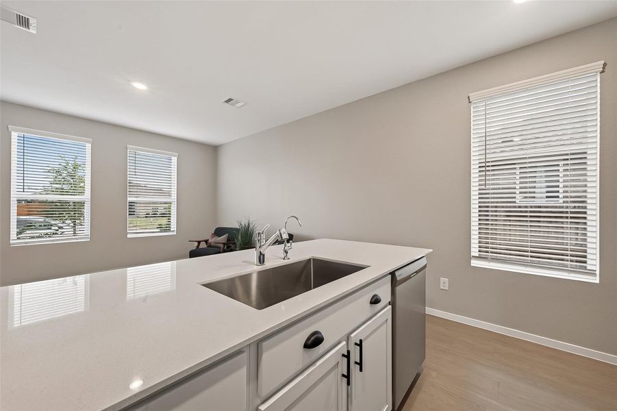 Bright guest suite kitchen with a large island, plentiful workspace, and natural light from multiple windows. Bright guest suite kitchen with a large island, plentiful workspace, and natural light from multiple windows.