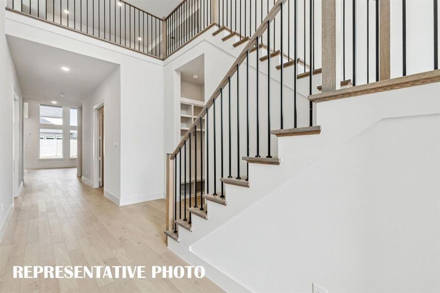 Featuring high ceilings, beautiful flooring, striking metal railings and sight lines from the front through to the rear of the home, the entry of our Addison III plan offers a grand space for you to welcome friends and family!  REPRESENTATIVE PHOTO