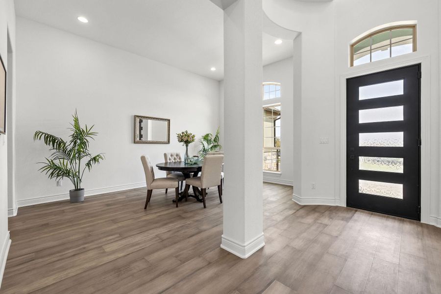 Foyer with healthy amount of natural light, wood finished floors, and recessed lighting