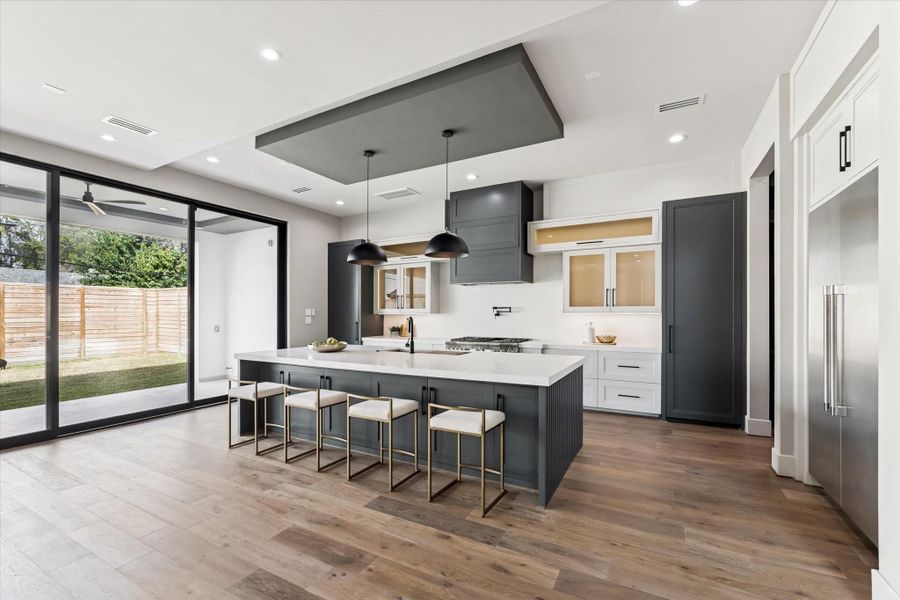 The kitchen features inset cabinetry and additional storage including pots and pan drawer, creating a clean, tailored look that blends seamlessly with the rest of the kitchen.