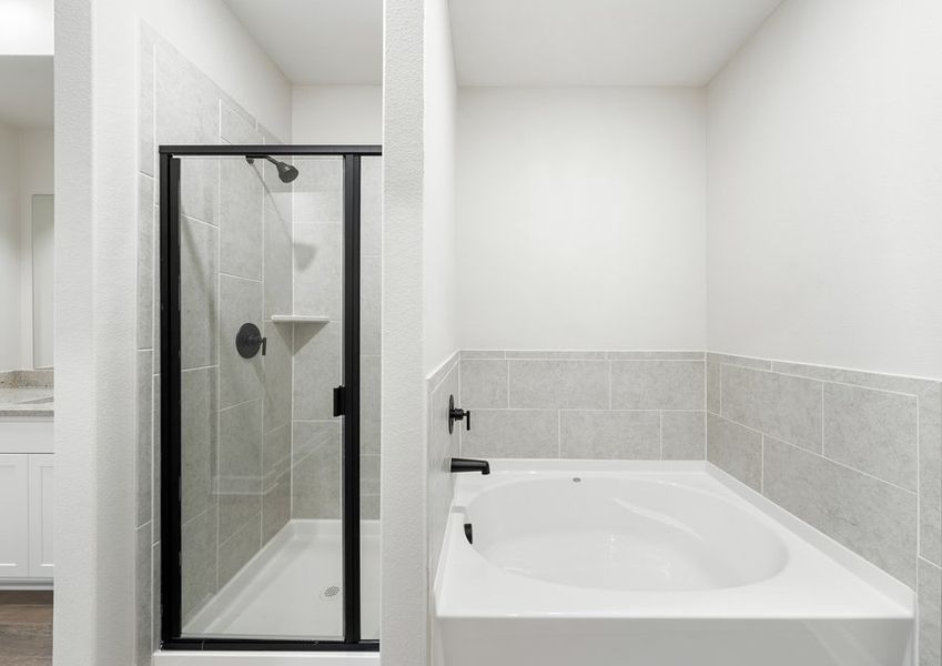 The master bathroom of the Driftwood has a glass, walk-in shower and large garden tub.