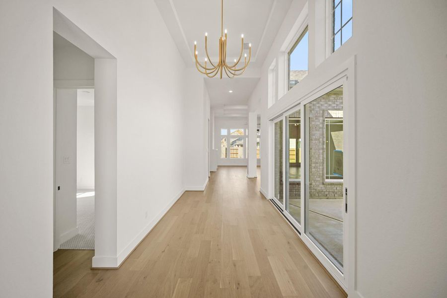 A spacious entryway, bathed in warm outdoor lighting that fills the room with a welcoming glow. A spacious entryway, bathed in warm outdoor lighting that fills the room with a welcoming glow.