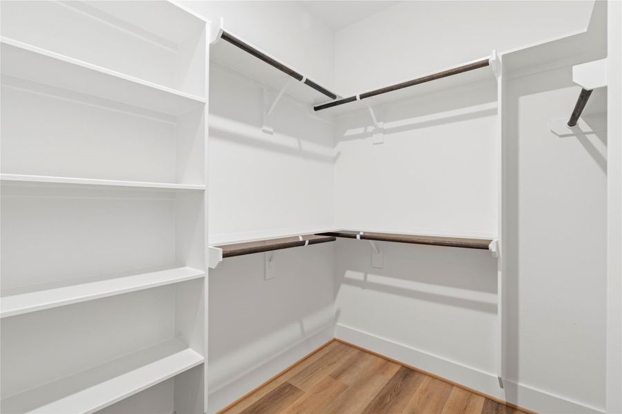 Featuring multiple hanging rods and integrated shelving, this well-designed closet makes it easy to keep everything in order.