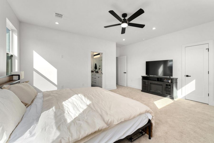 Bedroom with light carpet, a ceiling fan, recessed lighting, and ensuite bath