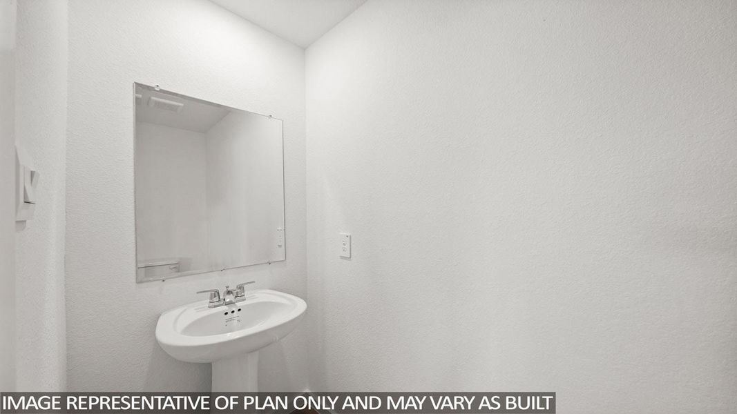 A pristine powder room with a sleek pedestal sink and frameless mirror. A pristine powder room with a sleek pedestal sink and frameless mirror.