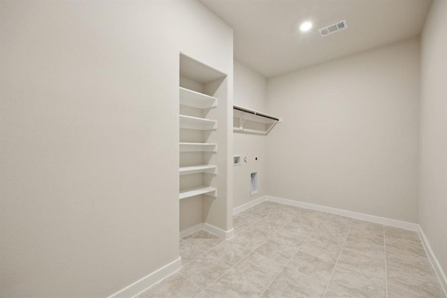 The oversized laundry room features built-in storage.