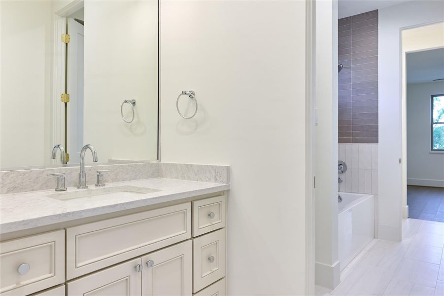 The Jack and Jill bathroom is thoughtfully designed with dual sinks, each featuring sleek quartz countertops, providing both style and practicality for shared use between the two bedrooms. The Jack and Jill bathroom is thoughtfully designed with dual sinks, each featuring sleek quartz countertops, providing both style and practicality for shared use between the two bedrooms.