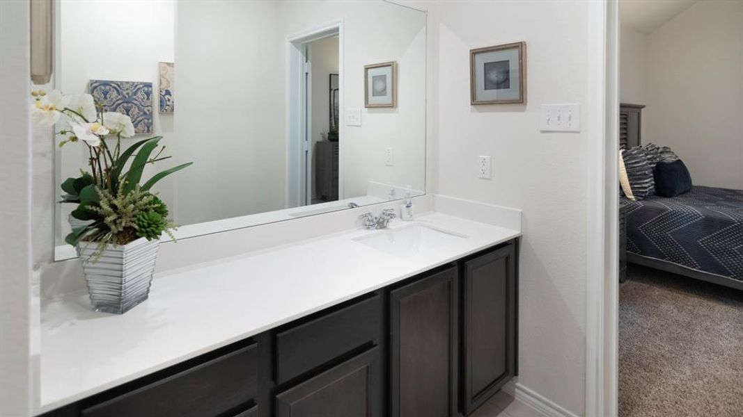 Ensuite bathroom featuring vanity and light colored carpet