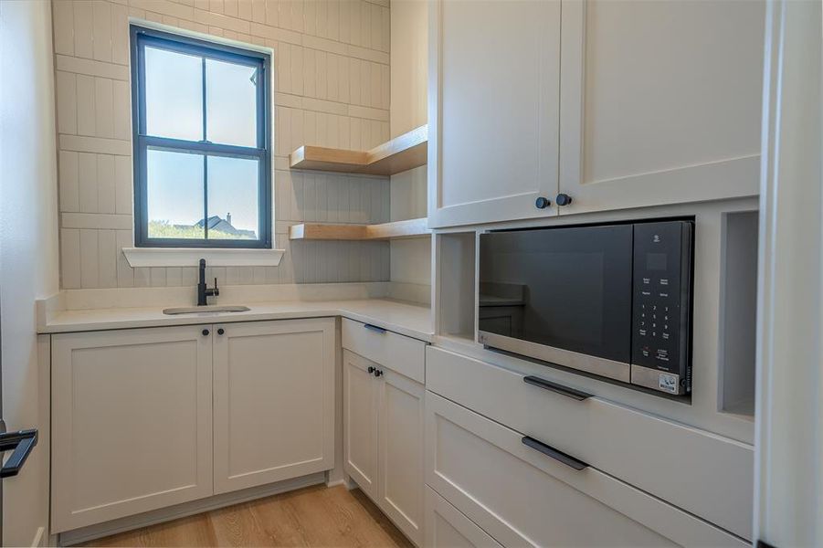 Kitchen featuring sink, white cabinets, and light wood-type flooring