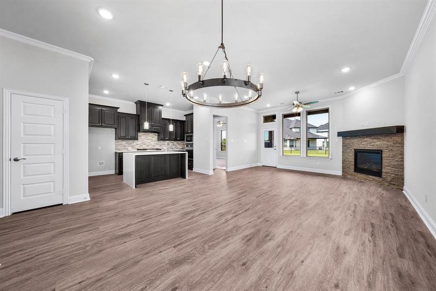 Open floorplan looking into the kitchen, living and dining rooms. Features crown molding and luxury vinyl flooring. Open floorplan looking into the kitchen, living and dining rooms. Features crown molding and luxury vinyl flooring.